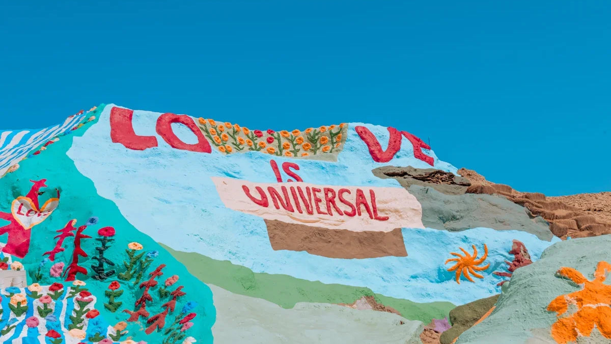 a colorfully painted mountain with a sign that says love is universal