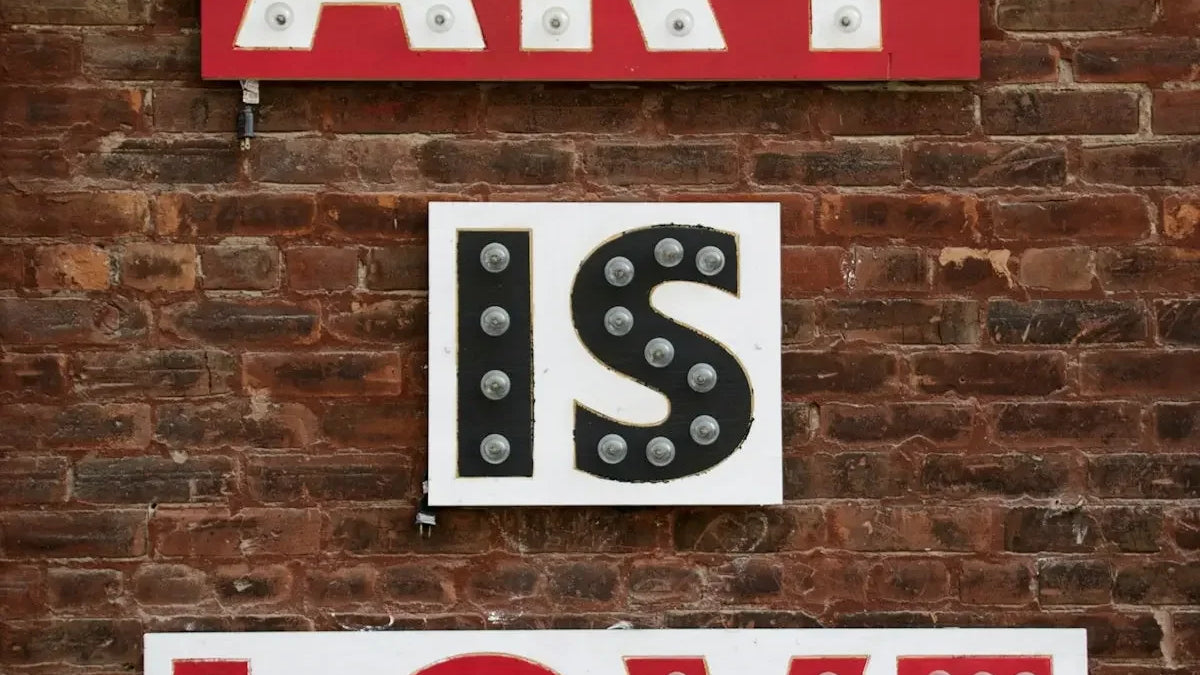 a sign that says art is love on a brick wall