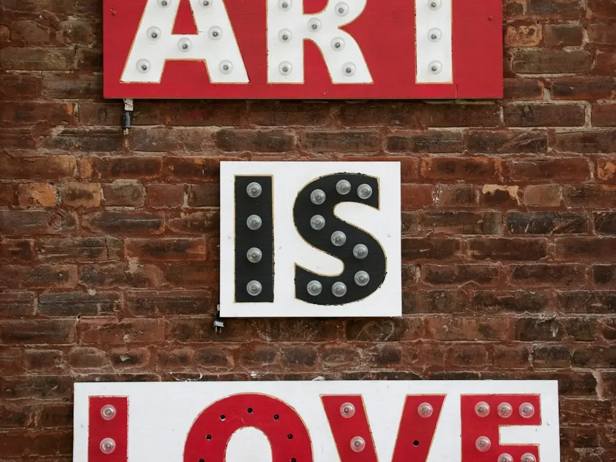 a sign that says art is love on a brick wall