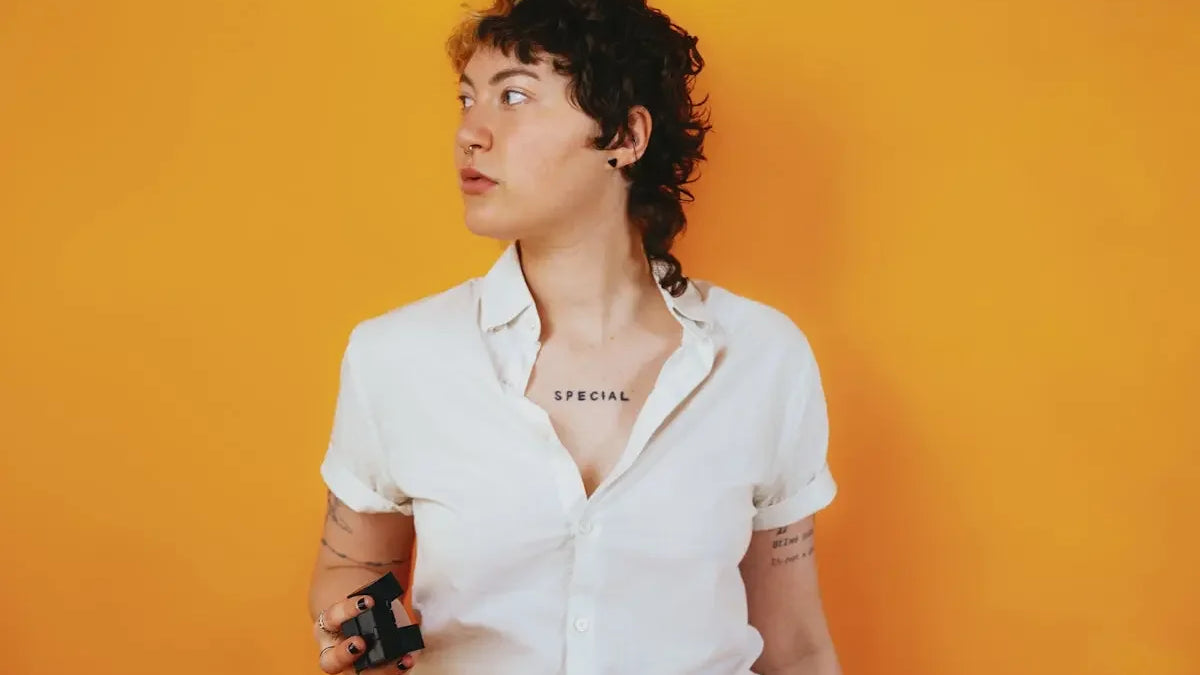 Portrait of a nonbinary autistic person in a studio setting with a stim toy in their hand